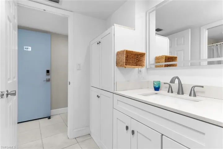 Bathroom featuring vanity, light tile patterned flooring, and a shower with shower curtain