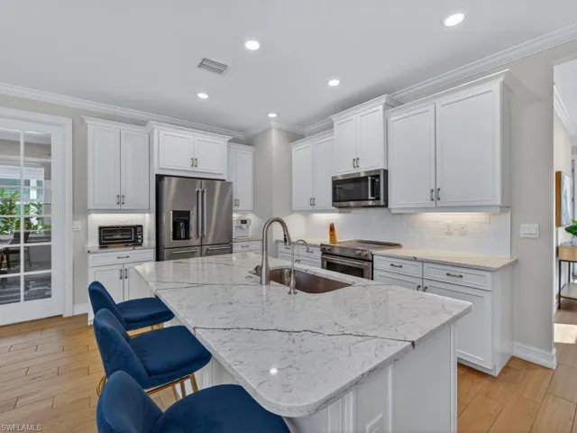Beautiful white kitchen with quartz countertops and abundant cabinetry.