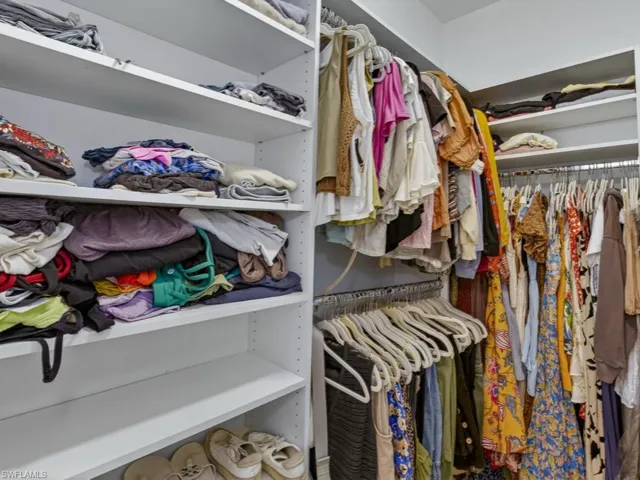 Generous custom walk-in closet with built-in shelving.