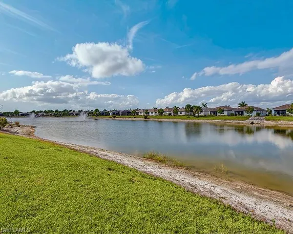 Peaceful community lake with fountains creating a serene waterfront setting.