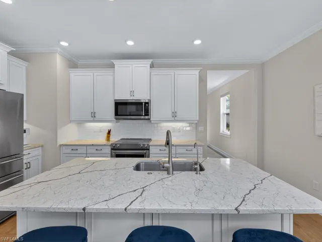 Spacious kitchen featuring a large quartz island and Kitchen Aid stainless appliances.