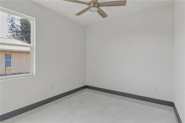 Spare room with baseboards and a ceiling fan