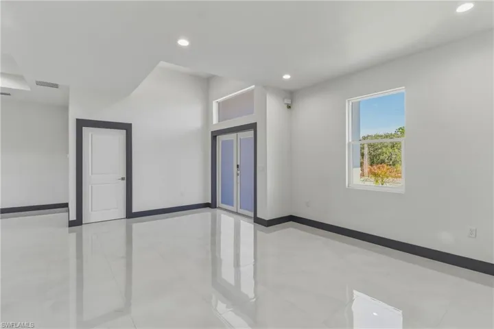 Empty room with french doors, recessed lighting, and light tile patterned floors