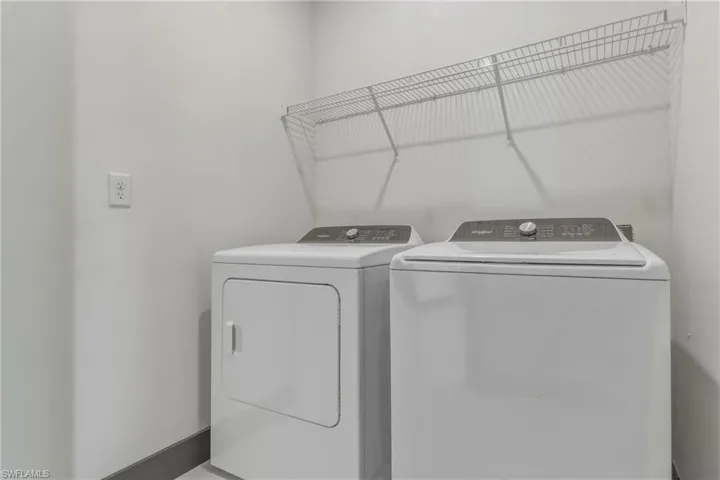 Laundry room featuring independent washer and dryer and baseboards