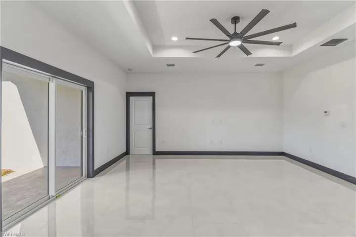 Unfurnished room with ceiling fan, a tray ceiling, and recessed lighting