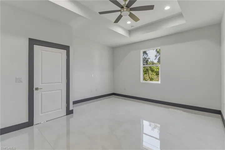 Unfurnished room featuring recessed lighting, a tray ceiling, and ceiling fan