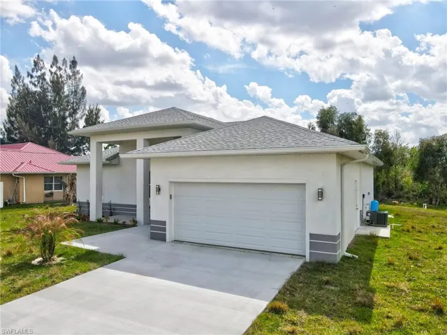 View of front of property featuring a garage, stucco siding, driveway, roof with shingles, and a front yard