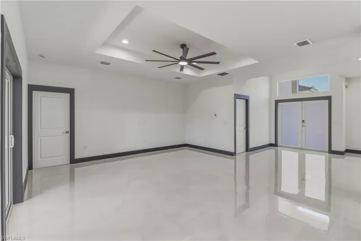 Unfurnished room featuring a tray ceiling, a ceiling fan, and recessed lighting