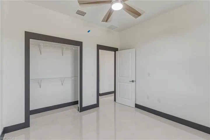 Unfurnished bedroom featuring a ceiling fan and a closet