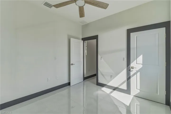 Empty room featuring baseboards and a ceiling fan