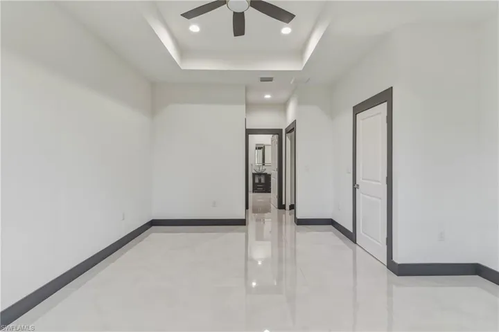 Spare room with recessed lighting, a raised ceiling, and ceiling fan