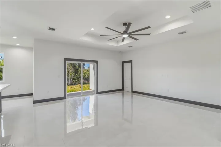 Spare room featuring a raised ceiling, a ceiling fan, recessed lighting, and light tile patterned floors
