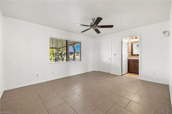 Unfurnished room featuring ceiling fan and light tile floors
