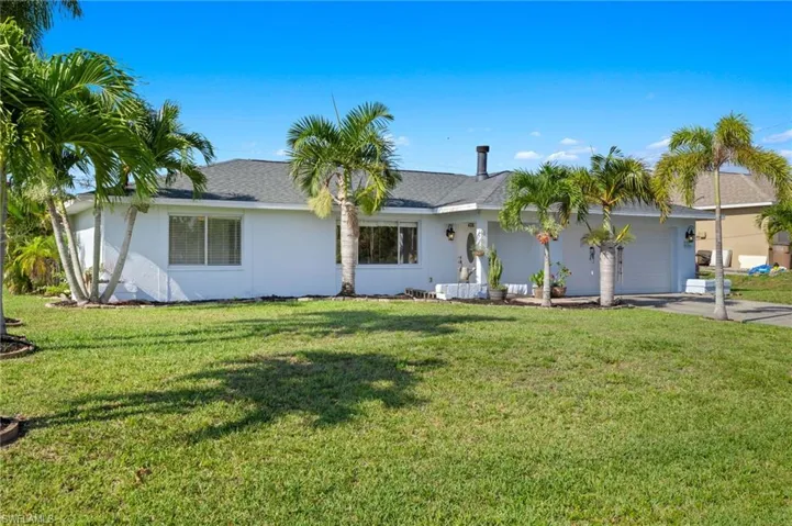 Ranch-style home featuring a front lawn and a garage