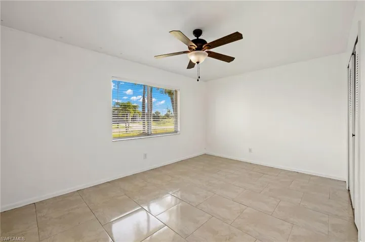 Spare room with ceiling fan and light tile floors