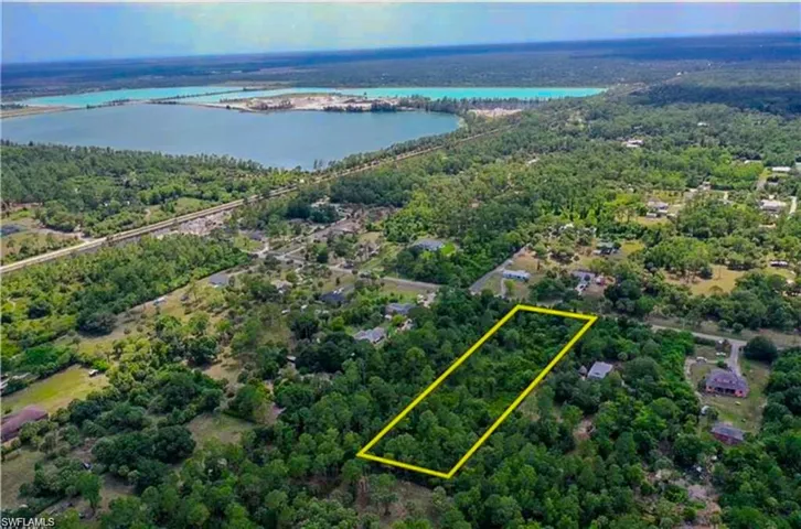 Aerial view of property and surrounding area featuring property parcel outlined and a notable bridge