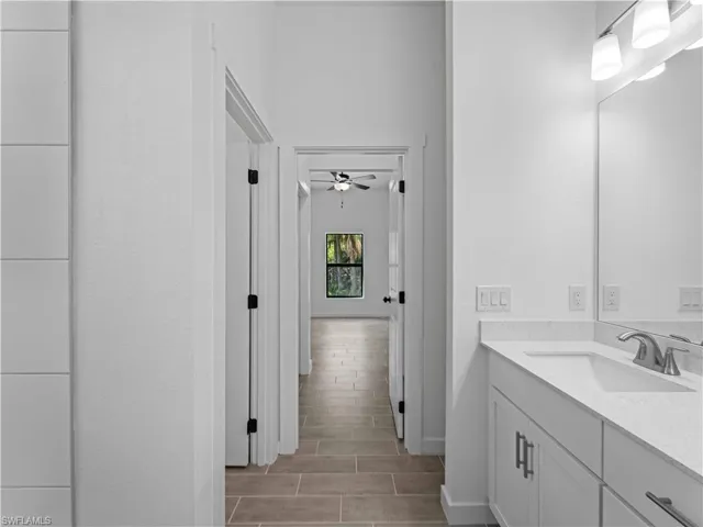 Bathroom featuring hardwood / wood-style flooring, vanity, and ceiling fan