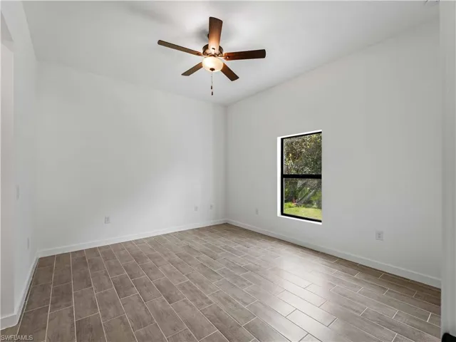 Unfurnished room with ceiling fan and light hardwood / wood-style flooring