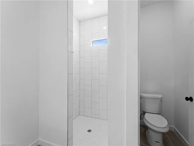 Bathroom with toilet and a tile shower