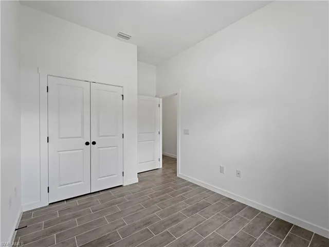 Unfurnished bedroom with a closet and hardwood / wood-style floors