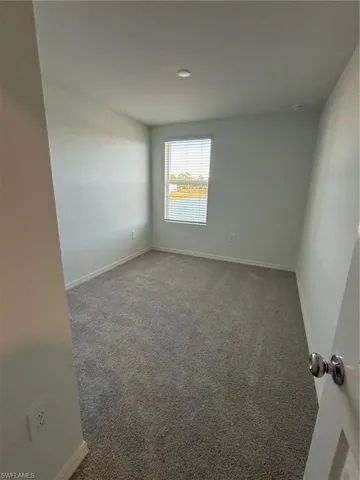 Carpeted empty room with baseboards