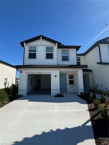 View of front facade with driveway, an attached garage, stucco siding, and a porch