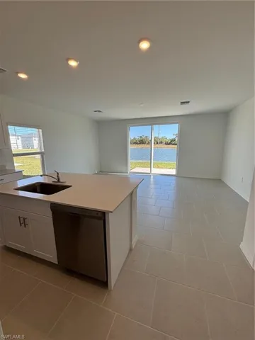 Kitchen with white cabinetry, open floor plan, dishwasher, a water view, and recessed lighting