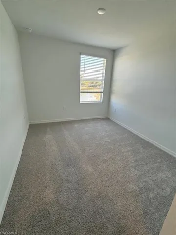 Unfurnished room featuring carpet flooring and baseboards