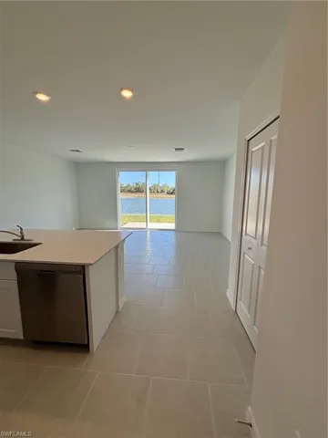 Hall with a water view, light tile patterned flooring, and recessed lighting
