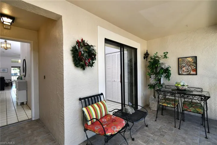 Entrance to property with stucco siding and outdoor dining space