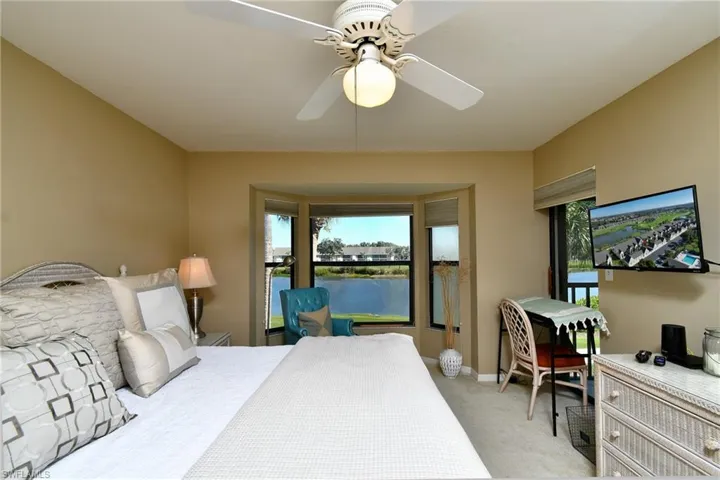 Bedroom with light colored carpet and a ceiling fan