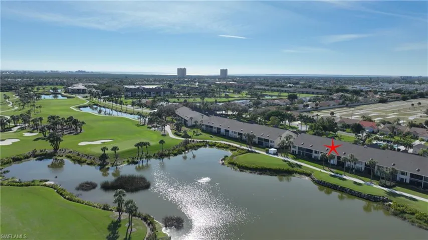 Drone / aerial view of a golf course and a nearby body of water