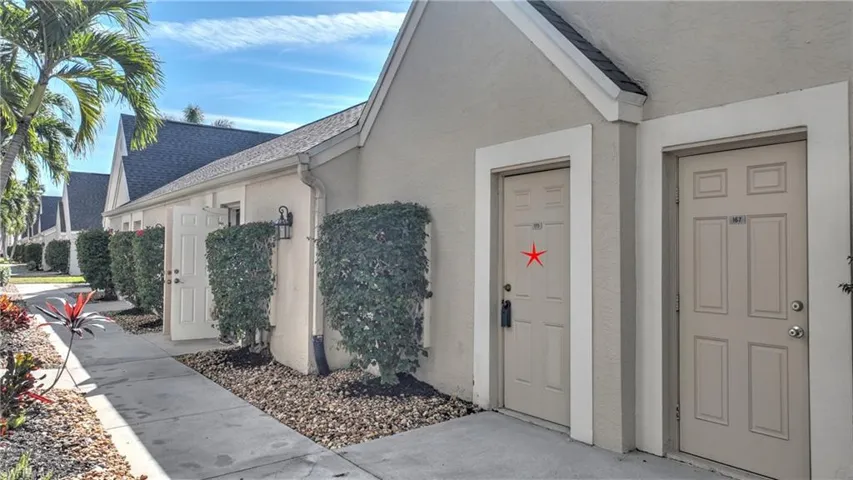 Doorway to property with a shingled roof and stucco siding