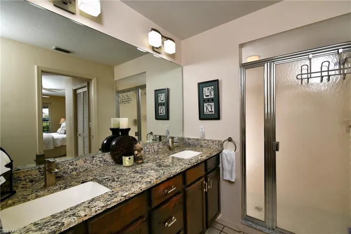 Bathroom with ensuite bath, double vanity, and a shower stall
