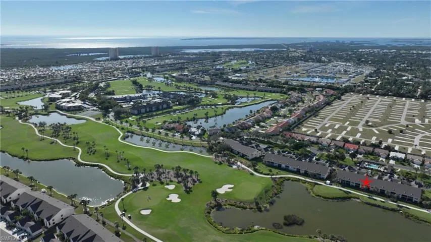 Aerial view of property's location featuring a large body of water and nearby suburban area