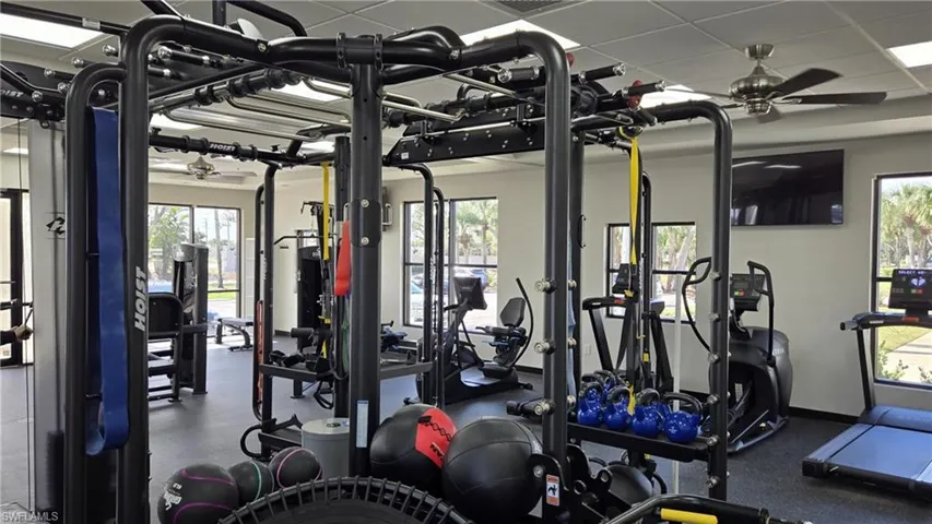 Exercise room featuring ceiling fan and a paneled ceiling