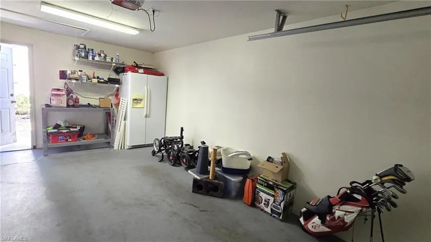 Garage with white refrigerator with ice dispenser
