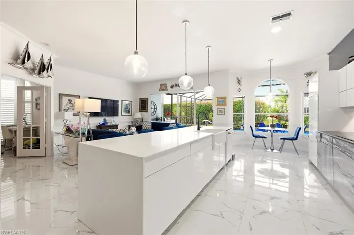 Kitchen featuring modern cabinets, white cabinets, open floor plan, and pendant lighting