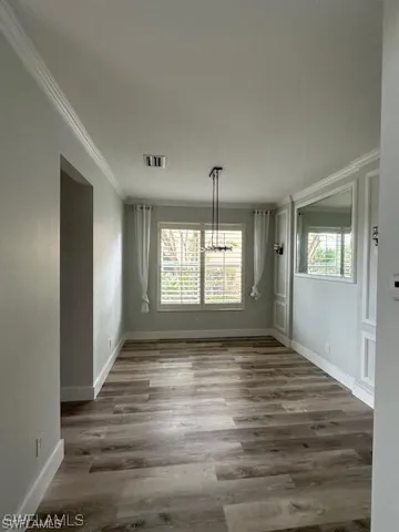 Formal Dining Room area with light luxury Vinyl finished floors and crown molding