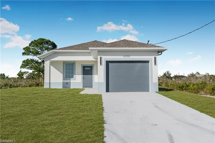 View of front of house with driveway, a front yard, stucco siding, an attached garage, and roof with shingles