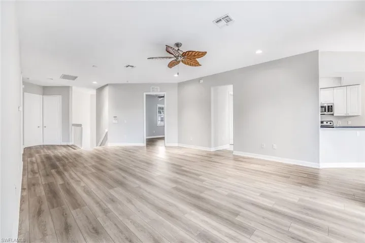 Unfurnished living room featuring ceiling fan, light wood-style floors, and recessed lighting