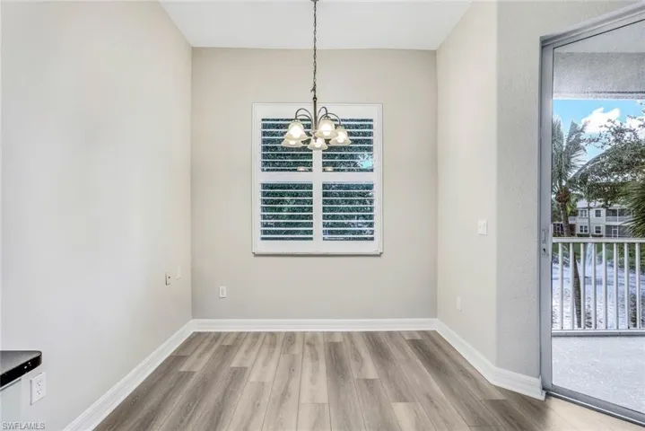 Unfurnished dining area featuring wood finished floors and a chandelier