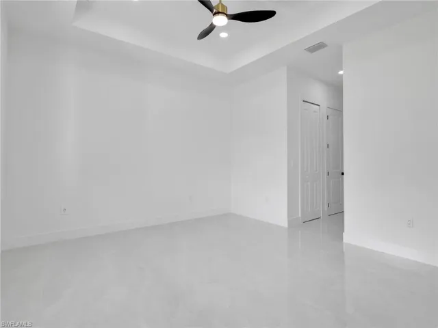 Unfurnished room featuring a ceiling fan, a tray ceiling, and recessed lighting