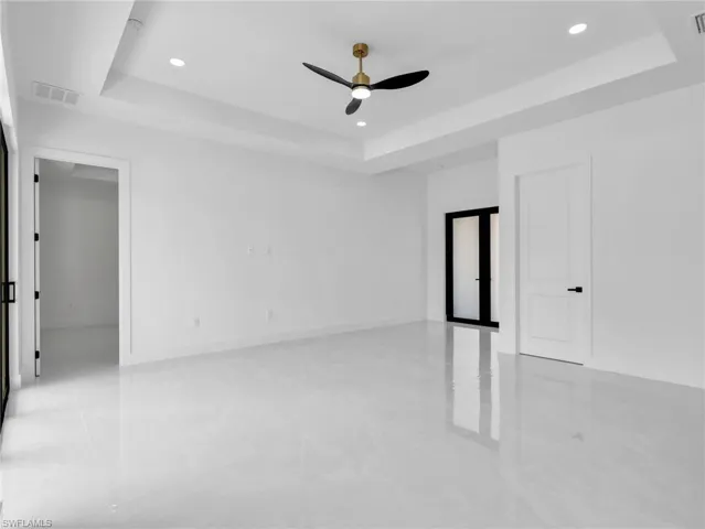 Unfurnished room featuring a tray ceiling, ceiling fan, and recessed lighting