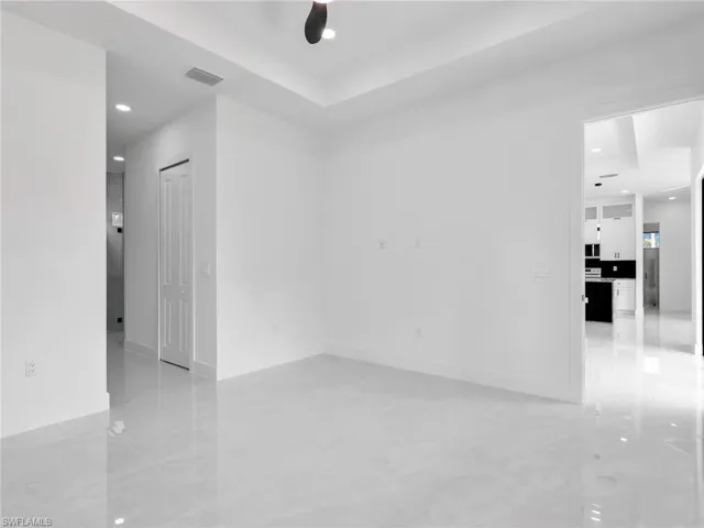 Empty room with recessed lighting, a ceiling fan, and a raised ceiling
