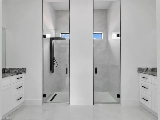 Bathroom with vanity and a marble finish shower