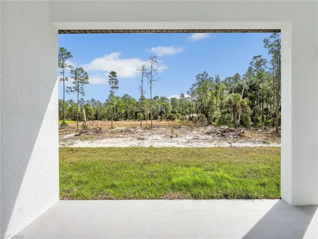 View of yard with view of wooded area and a patio