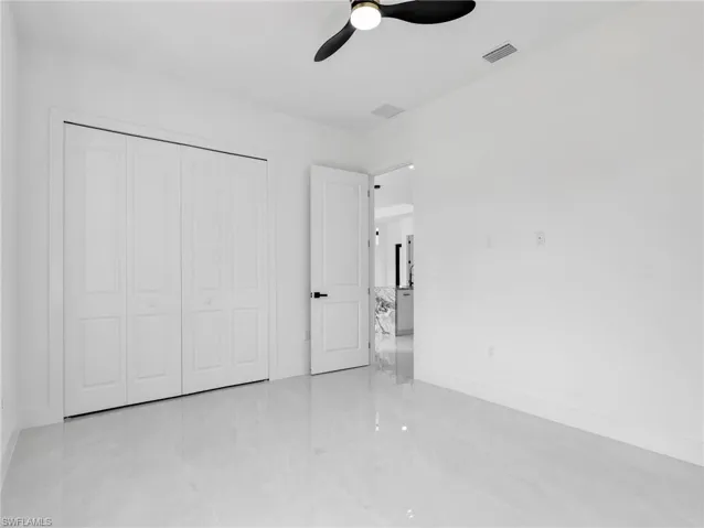 Unfurnished bedroom with ceiling fan and a closet