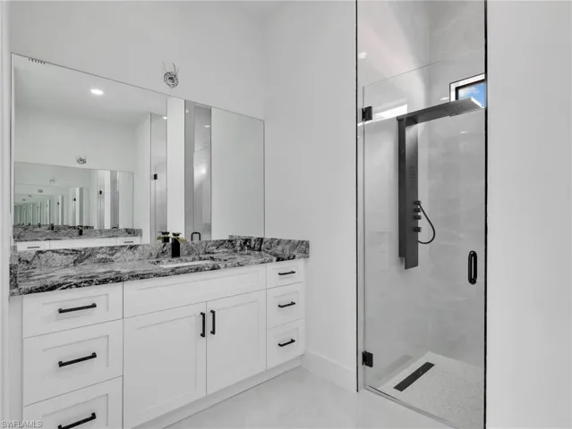 Bathroom featuring a shower stall and vanity