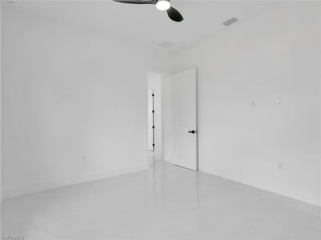 Unfurnished room featuring concrete flooring and a ceiling fan